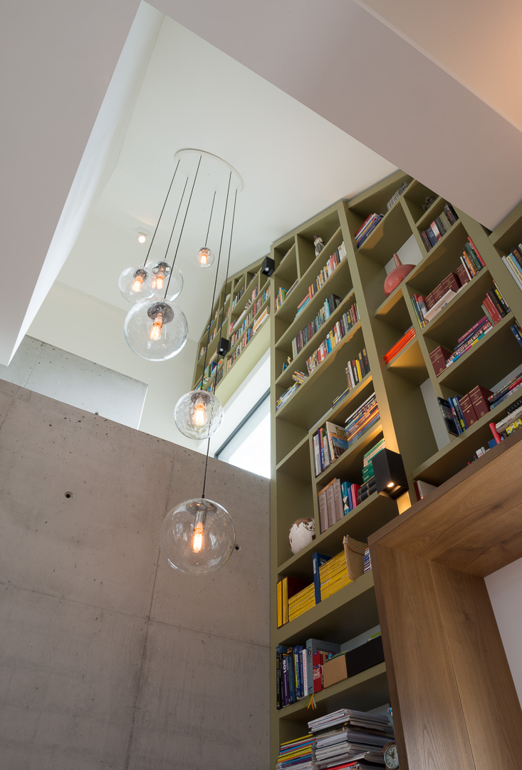 Boekenkast op maat gemaakt, meelopend in het lijnenspel van de buitengevel van de woning. De boekenkast is gemaakt van MDF in een warm groene kleur gespoten.